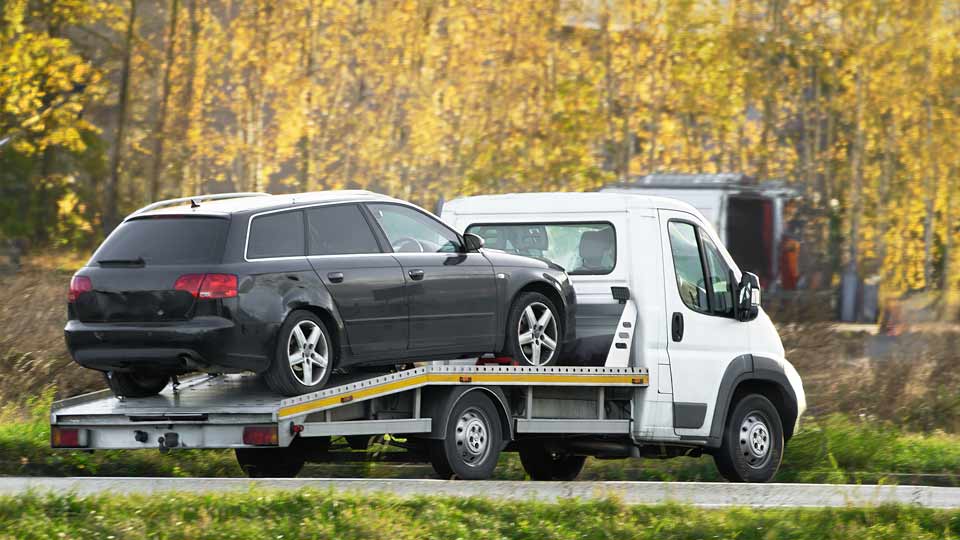 Ein Auto wird auf einem Abschleppwagen verladen und kostenlos bei Autoankauf Dachau abgeholt 